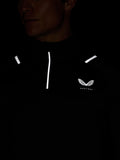 Dark image of a model in a black Apex Thermal Winterised ¼ zip top showing reflective accents on the shoulders and the Castore wing logo on the chest