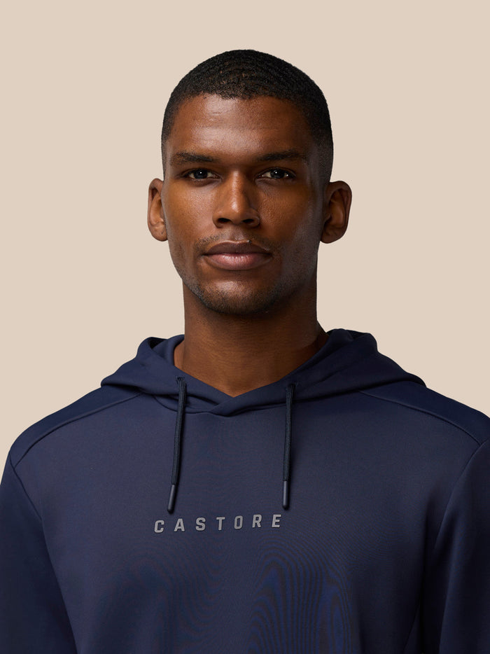 Male model wearing navy Flex Lifestyle Thermo Hoodie with Castore wordmark centered on the chest