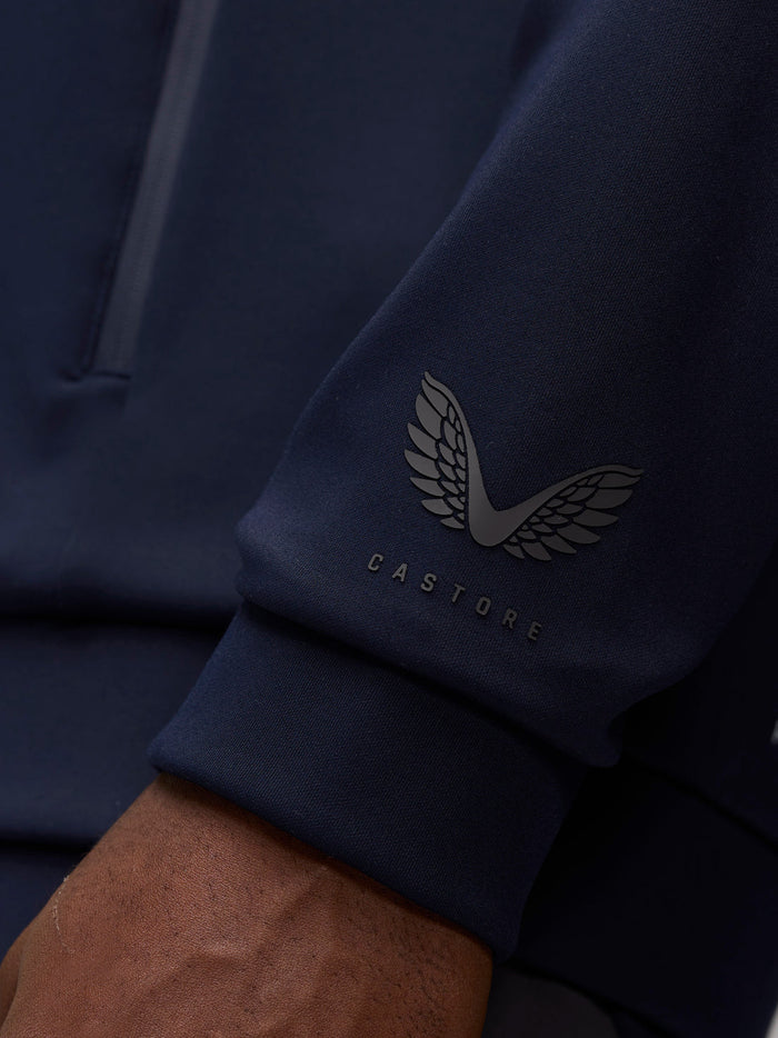 Close up of navy hoodie sleeve showing Castore logo on the cuff area