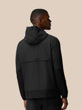 Back view of male model in black hooded jacket showing textured lower hem and patterned sleeves