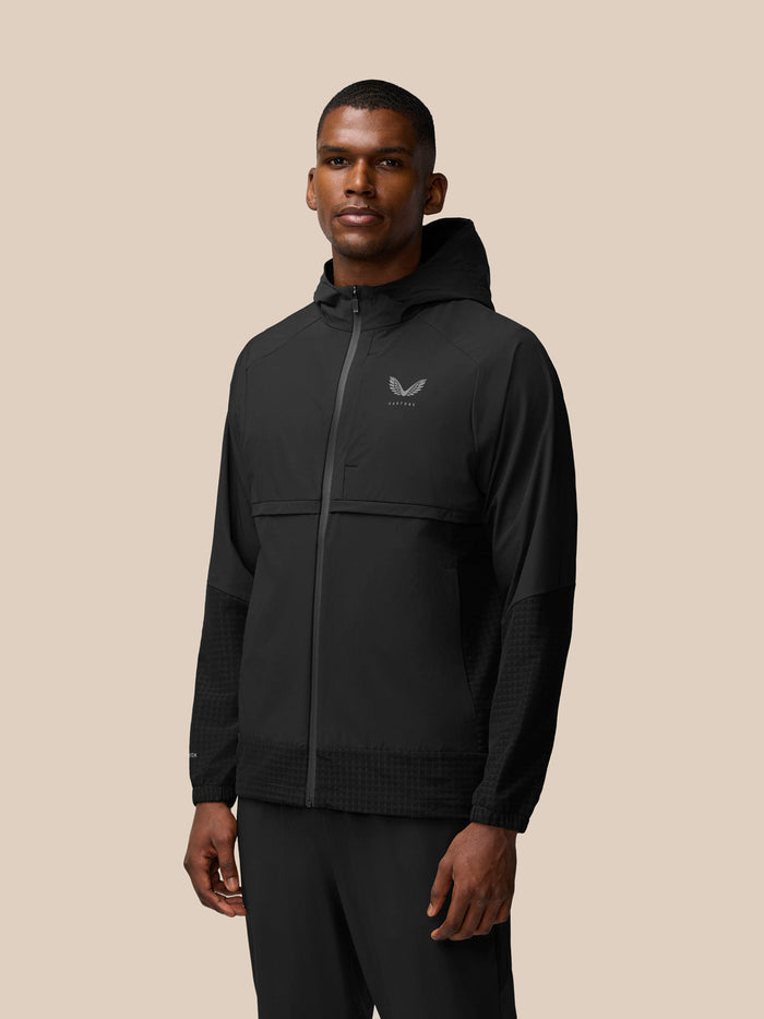 Rear view of male model in black hooded Flex Winterised Woven Jacket with subtle sleeve texture