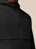 Close up of black jacket upper torso with a front zipper and Castore emblem on left chest