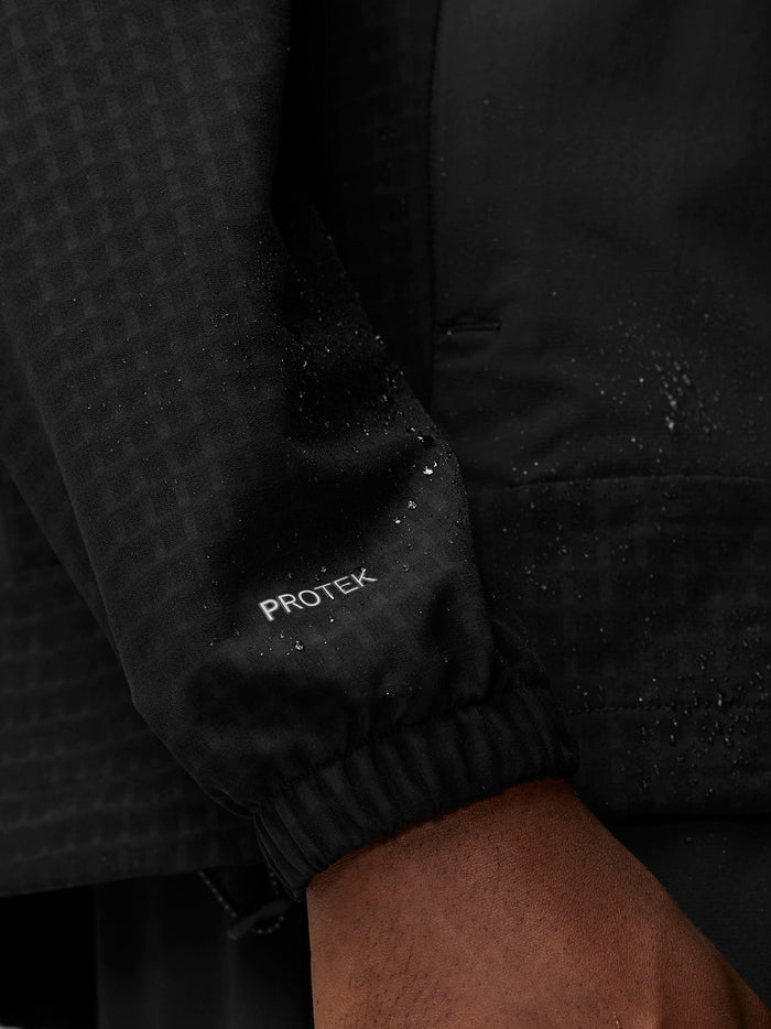 Close up of black ProTek water resistant jacket sleeve with droplets and elastic cuff