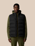Man wearing black sleeveless puffer gilet over olive green hoodie with front zip.