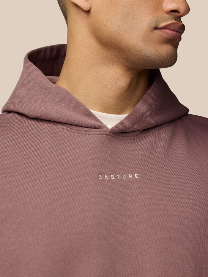Close-up of the mauve Adapt Lifestyle Hoodie with hood up and Castore embroidery on the chest.