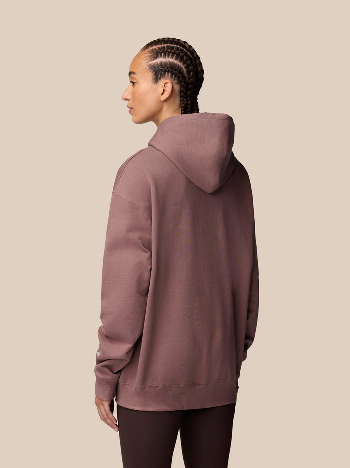 Back view of mauve Adapt Lifestyle Hoodie on a man with cornrows and hood up
