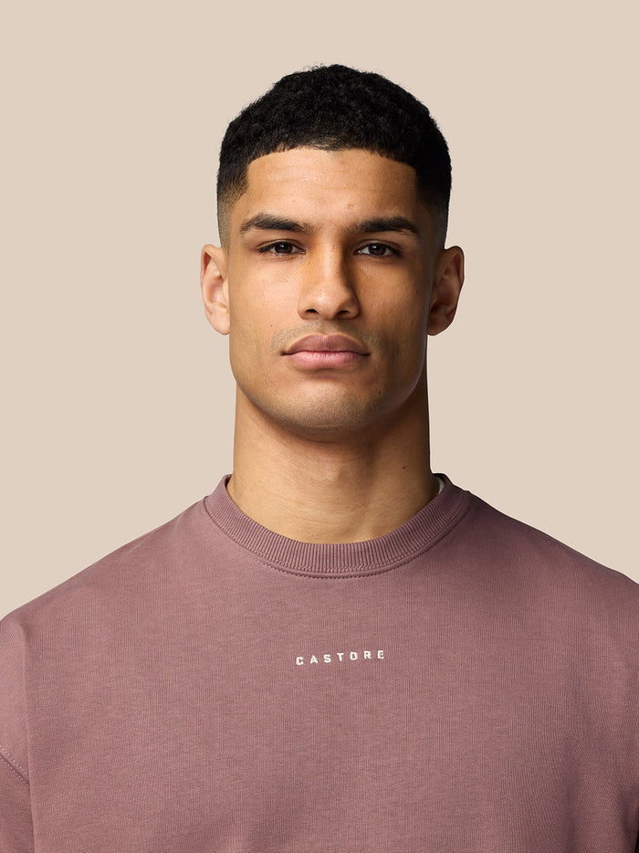 Front view of a mauve oversized cotton sweatshirt with Castore logo on the chest