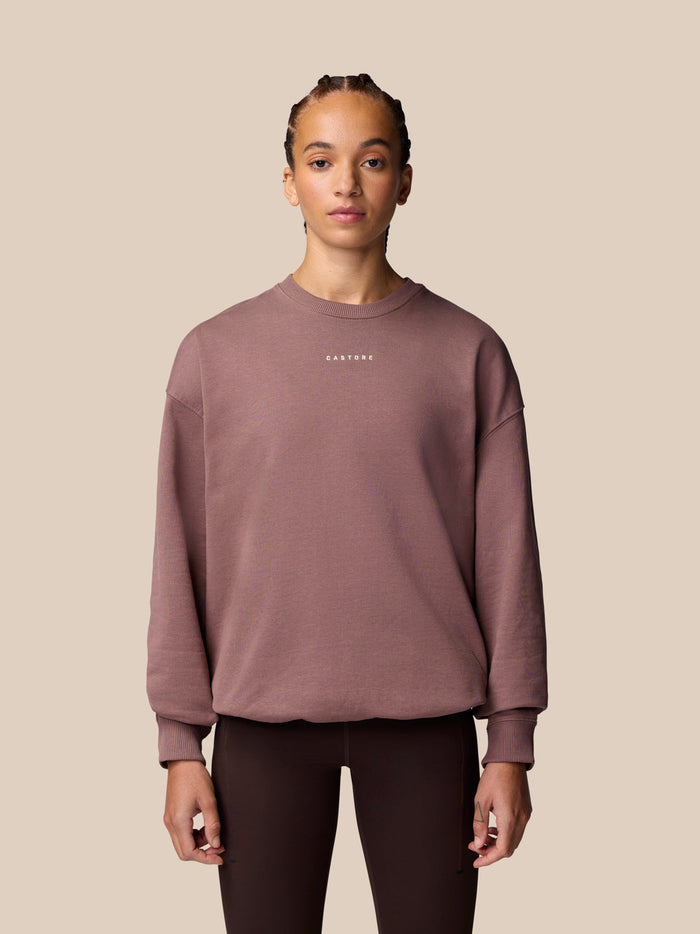 Female model wearing mauve ADAPT LIFESTYLE SWEATSHIRT with oversized silhouette and crew neckline