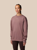 Model wearing mauve oversized sweatshirt with small white Castore logo on the chest