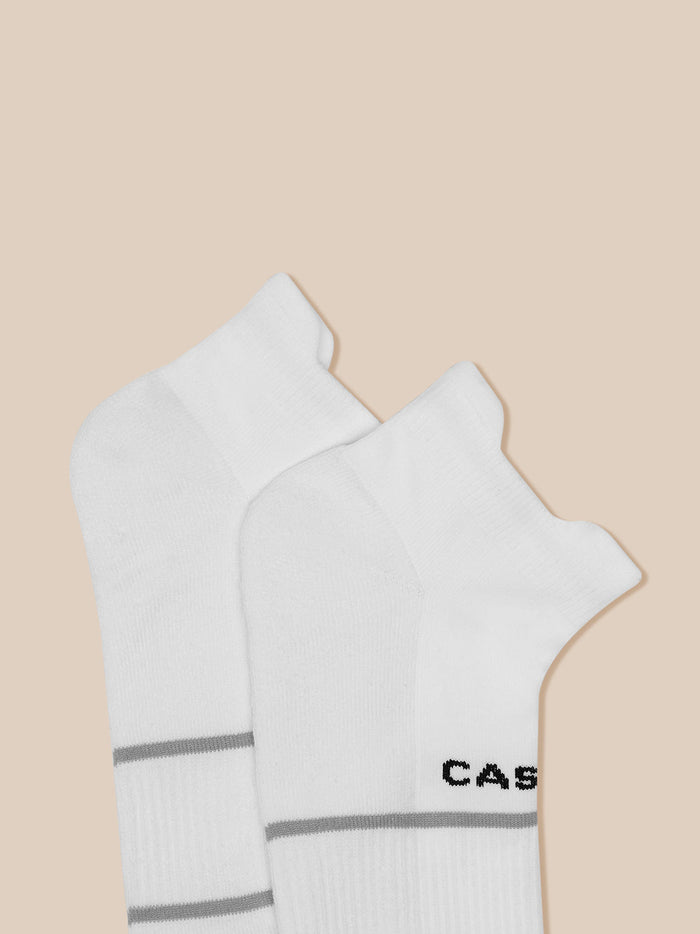 White athletic socks with grey banding and Castore logo visible at the cuff