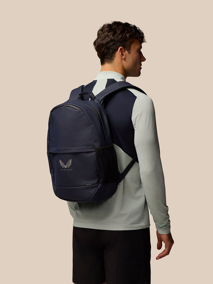 Model wearing navy backpack on the back, showcasing padded straps and compact design.