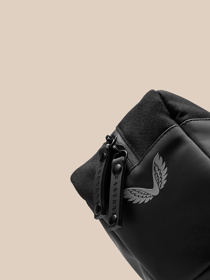 Close up of a black Active Wash Bag showing rugged zipper pulls and durable fabric with a wing logo.