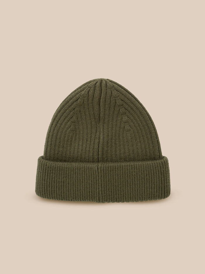Ivy green ribbed knit beanie with folded cuff and Castore logo patch against a neutral beige background