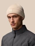 Stone ribbed knit beanie on a model with Castore logo patch at the foldover