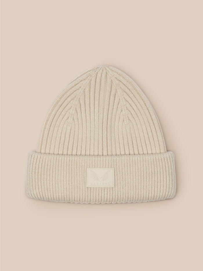 Stone ribbed knit beanie with folded brim and Castore logo patch visible