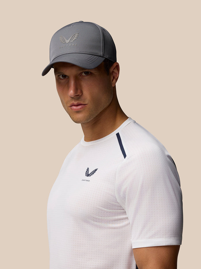 Male model wearing a gray Castore logo cap in a studio portrait