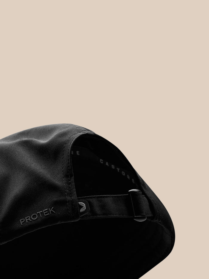Close-up of back and strap area of black nylon cap with adjustable buckle