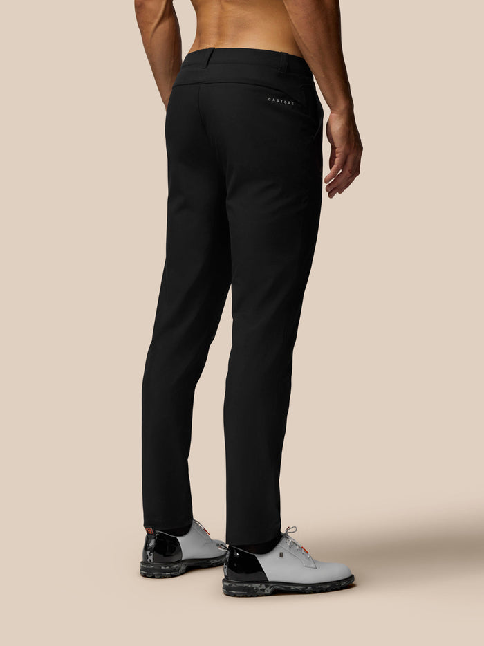 Back view of a man in black golf club trousers showing a welt back pocket and Castore branding.