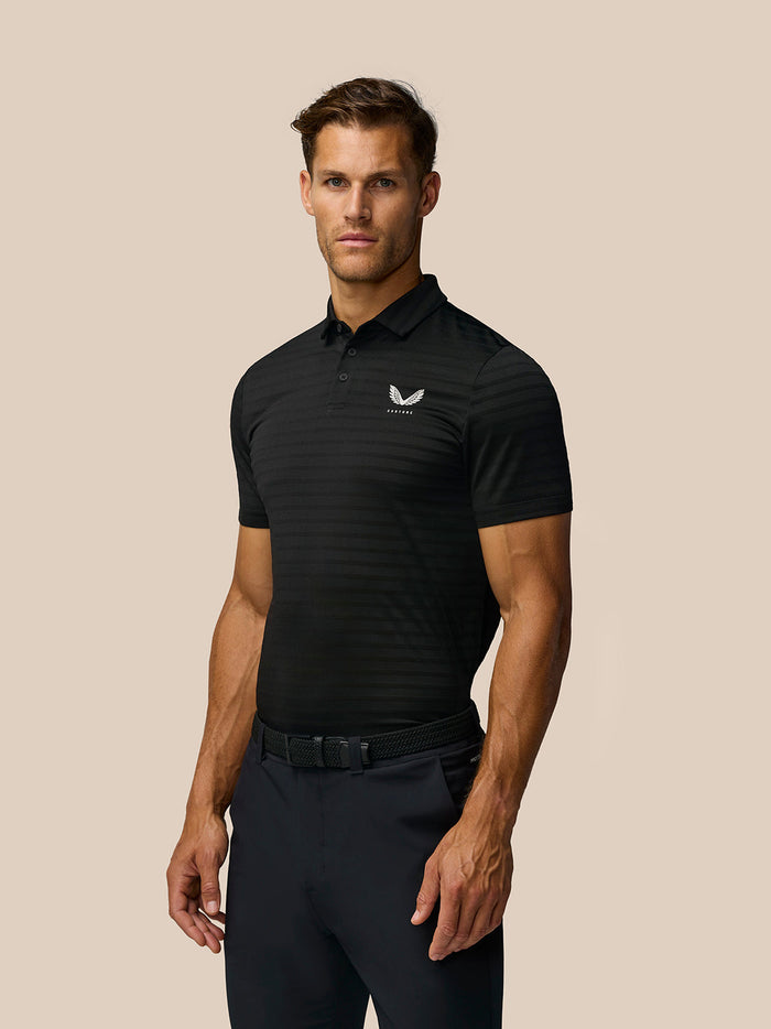 Male model in black Pinnacle Pique Stripe Polo with subtle stripes and Castore logo on left chest