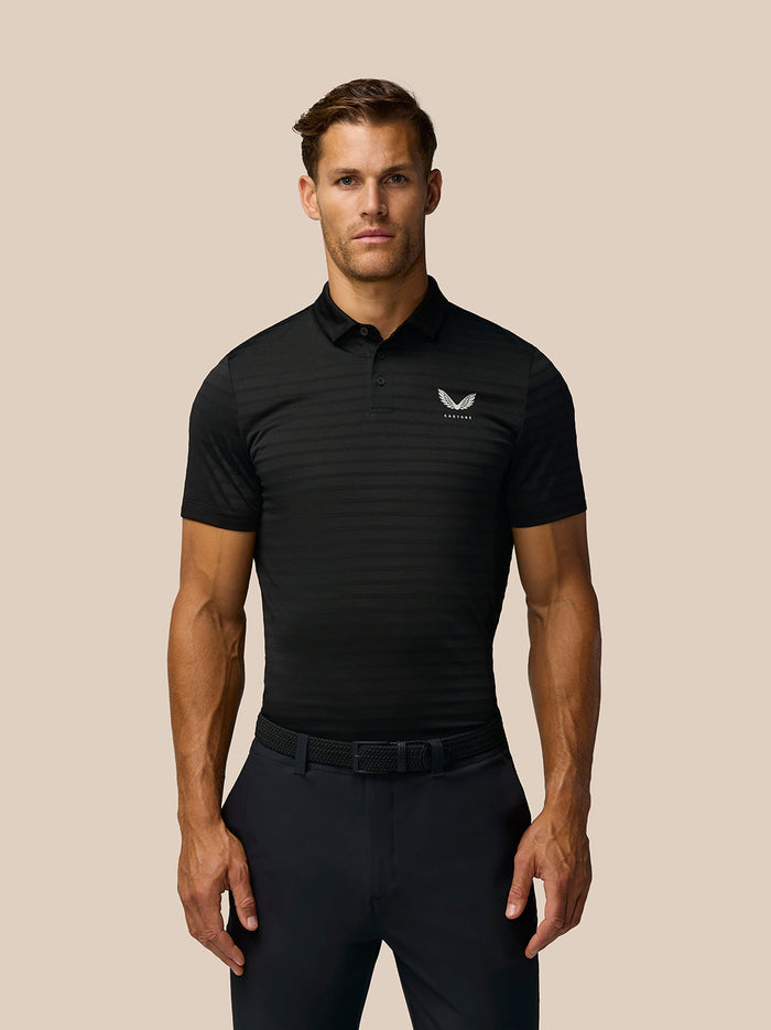 Man wearing black Pinnacle Pique Stripe Polo with all over stripe pattern and Castore logo on left chest