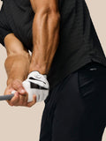 Close up of a golfer gripping a club in a black Pinnacle Pique Stripe polo with subtle stripes