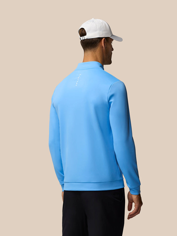 Back view of man wearing light blue Golf Club Classic quarter zip top
