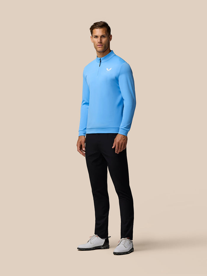 Three quarter back view of man wearing light blue Golf Club Classic quarter zip top