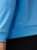 Close up of blue golf top fabric with droplets and the ProTek label
