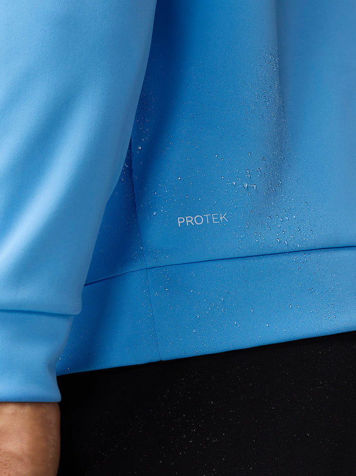 Close up of blue golf top fabric with droplets and the ProTek label