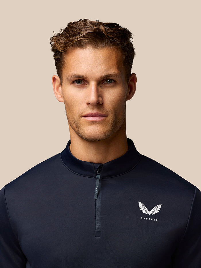 Close-up of GOLF CLUB CLASSIC 1/4 ZIP TOP in midnight navy with front zipper and Castore logo on the left chest.