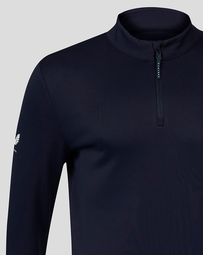 Detail of navy quarter zip highlighting shoulder and sleeve with a small logo on the left sleeve.