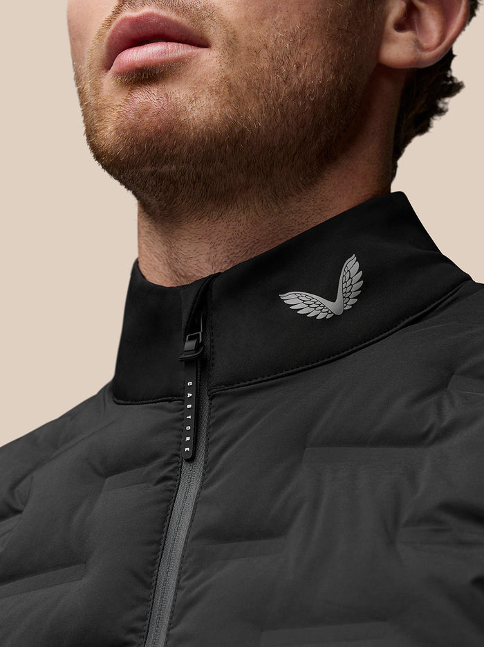 Close-up of black Protek gilet collar with a silver wing logo and zipper detail.
