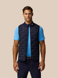 Male model wearing midnight navy Pinnacle gilet over a blue polo, showcasing sleeveless quilted design and stand collar