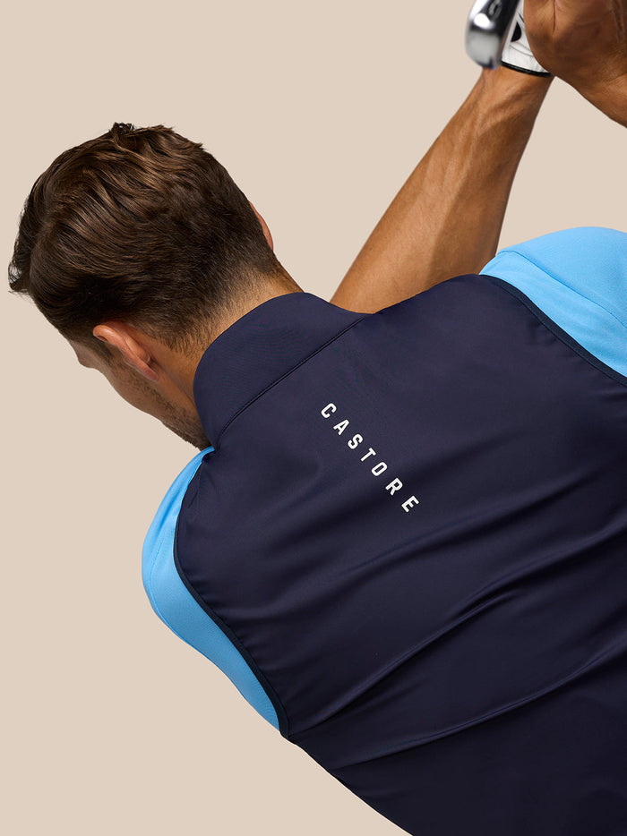 Back view of navy Pinnacle Gilet on a model, Castore branding on collar and upper back