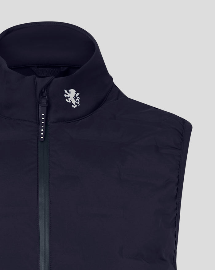 Close-up of navy gilet collar and vertical zipper with a white lion crest on the left chest.
