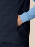 Male model wearing navy Pinnacle Gilet over a light-blue long-sleeve top