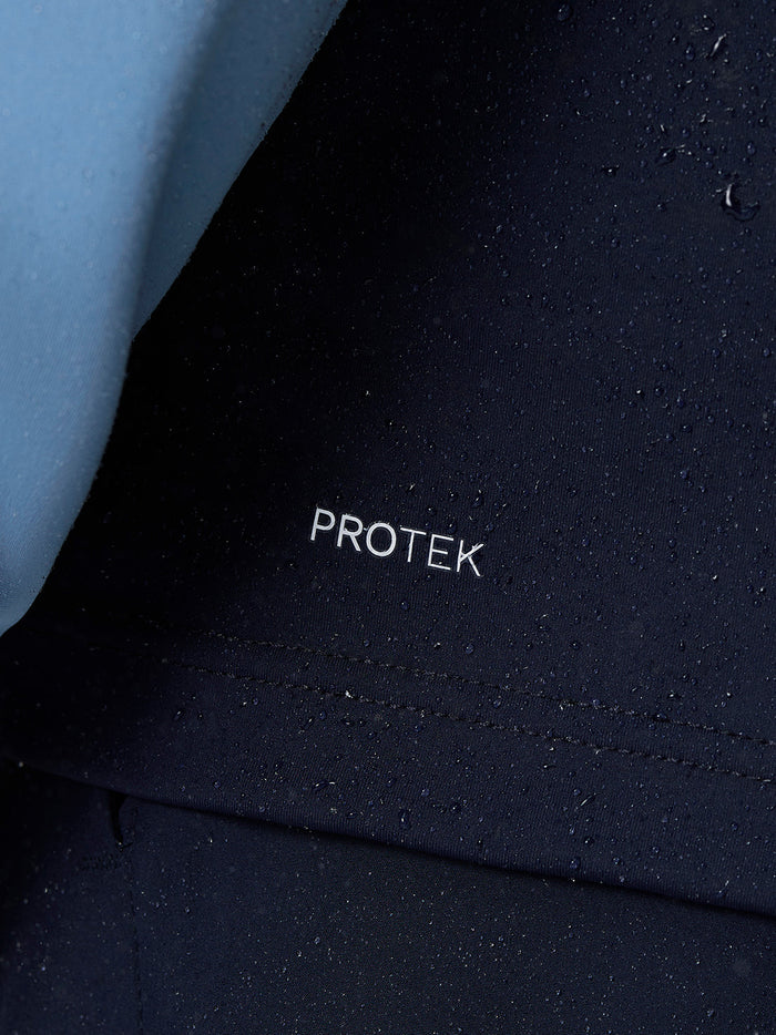 Close-up of navy golf gilet fabric with water droplets and Protek branding
