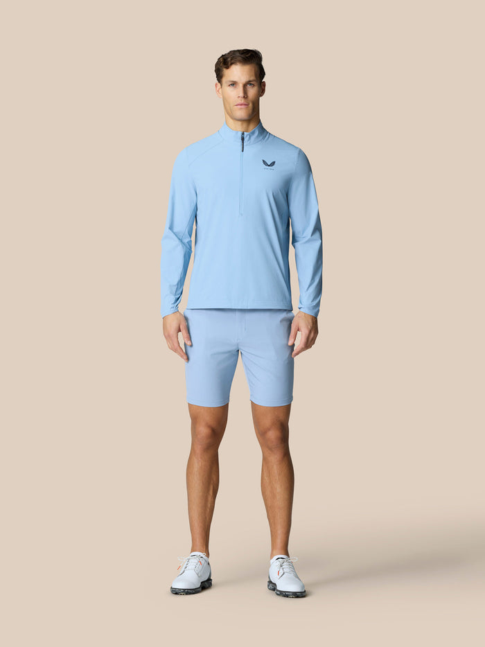 Model wearing sky blue Golf Flex Jacket with high funnel neckline and half zip front