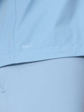 Close up of sky blue golf jacket fabric with water droplets and ProTek branding.