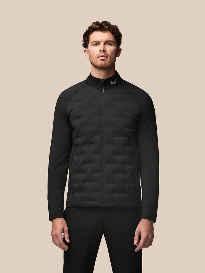 Male model wearing black Golf Pinnacle Jacket front view with quilted front panels and zip pockets.