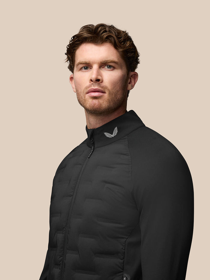 Male model wearing black Pinnacle Golf Jacket with stand collar and bonded front quilting