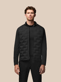 Male model wearing black Pinnacle Golf Jacket with quilted front panels and stand collar.