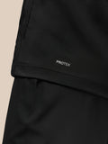 Close-up of lower back of black Pinnacle Golf Jacket showing PROTEK branding at the hem
