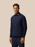 Male model wearing midnight navy Golf Pinnacle Jacket with quilted front panels stand collar and zip front
