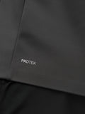 Close-up of dark jacket fabric showing Protek branding near the hem.