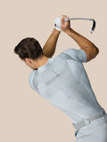 Golfer seen from behind in a light grey Pinnacle LVS Polo, showing back panel details.