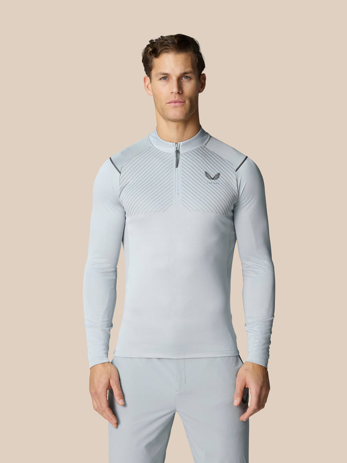 Male model wearing Pinnacle LVS 1/4 Zip Top in mid grey with front zip and chest logo