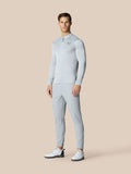 Full body shot of male model in matching light grey Pinnacle LVS 1/4 zip top and pants with white golf shoes