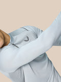 Chest close up of mid grey Pinnacle LVS 1/4 Zip Top showing collar zipper and winged emblem with striped knit pattern