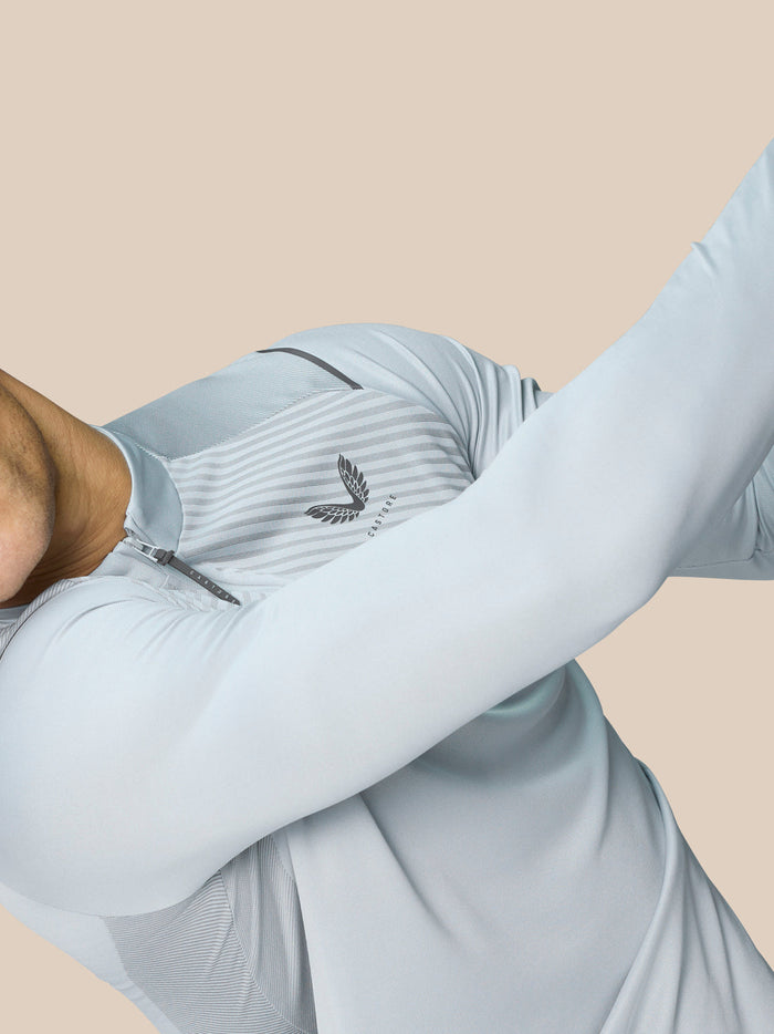 Chest close up of mid grey Pinnacle LVS 1/4 Zip Top showing collar zipper and winged emblem with striped knit pattern